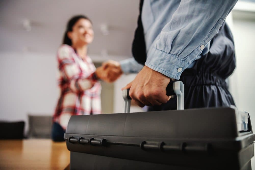 A Gold Medal technician shaking the hand of a smiling homeowner