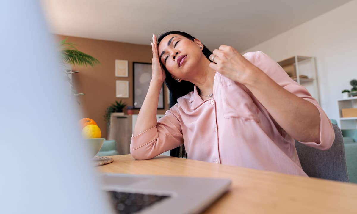 Woman sitting at computer in a hot room.