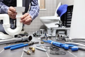 plumber repairing pipe in bathroom